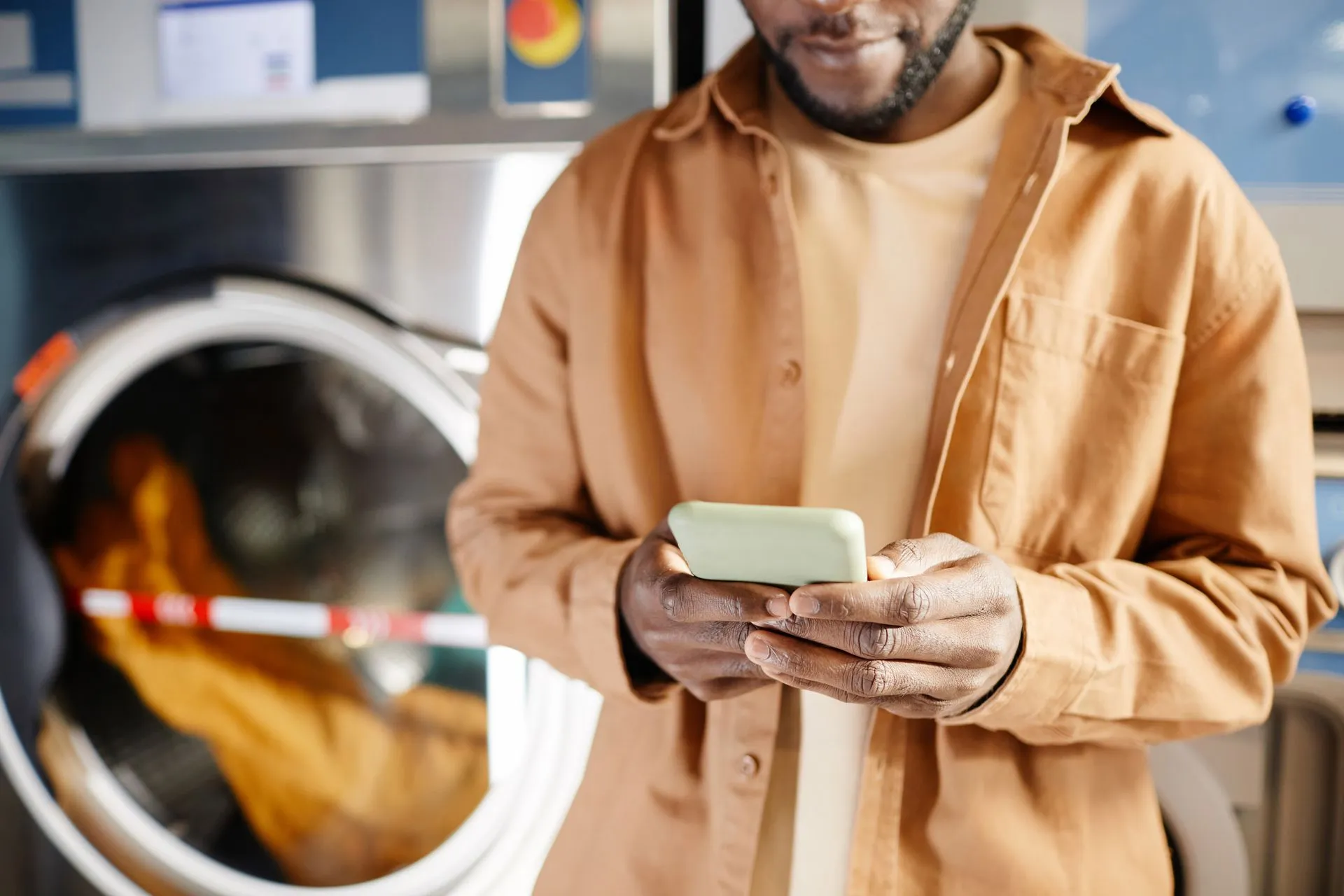 man on phone in front of washer
