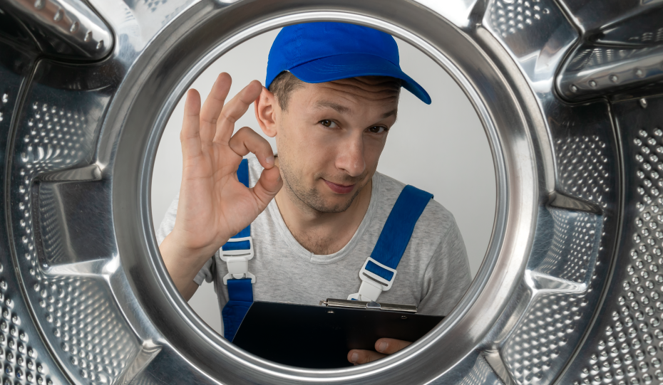 repair man looking into washer giving ok hand sign